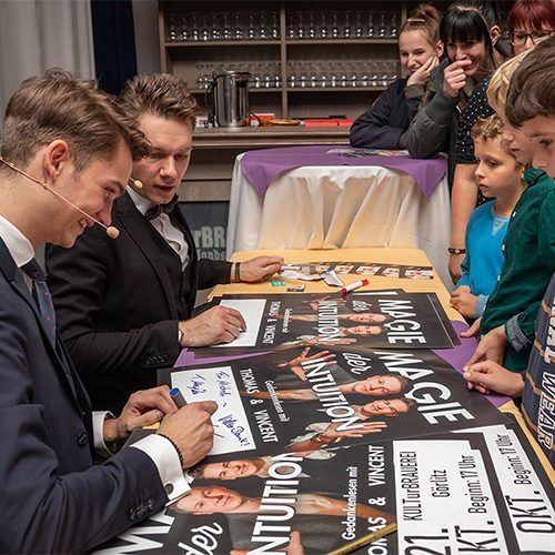 Autogrammstunde mit Vincent Frommer und Thomas Majka Vincent Frommer und Thomas Majka sitzen am Autogrammtisch bei einer öffentlichen Show